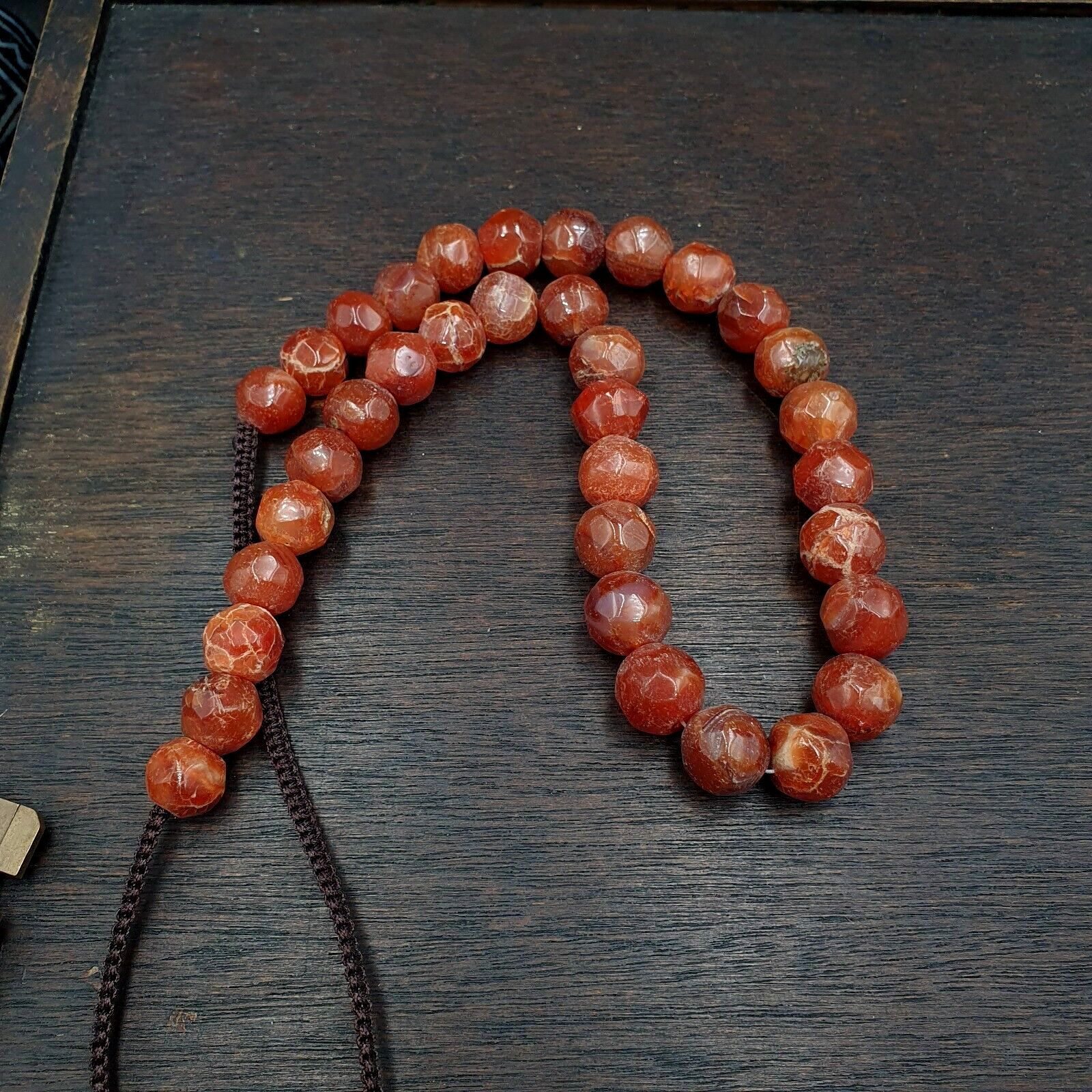 "Vintage Himalayan Tibetan necklace featuring faceted carnelian agate beads, expertly cut to reveal their warm, earthy tones and subtle patterns. Each bead is a testament to traditional Tibetan craftsmanship, making this necklace a unique and treasured possession."