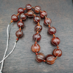 "Vintage Tibetan carnelian agate beads in a melon shape, strung together to form a beautiful beaded necklace, showcasing traditional Tibetan craftsmanship and the warm, earthy tones of carnelian agate."