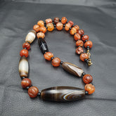 "YMN2: A stunning vintage necklace featuring Carnelian beads and Indo-Tibetan Himalayan Agate, showcasing a beautiful blend of earthy tones and cultural heritage. The Carnelian beads add a warm, sun-kissed glow, while the Agate beads bring a touch of elegance and sophistication, making this necklace a true treasure for collectors and enthusiasts."