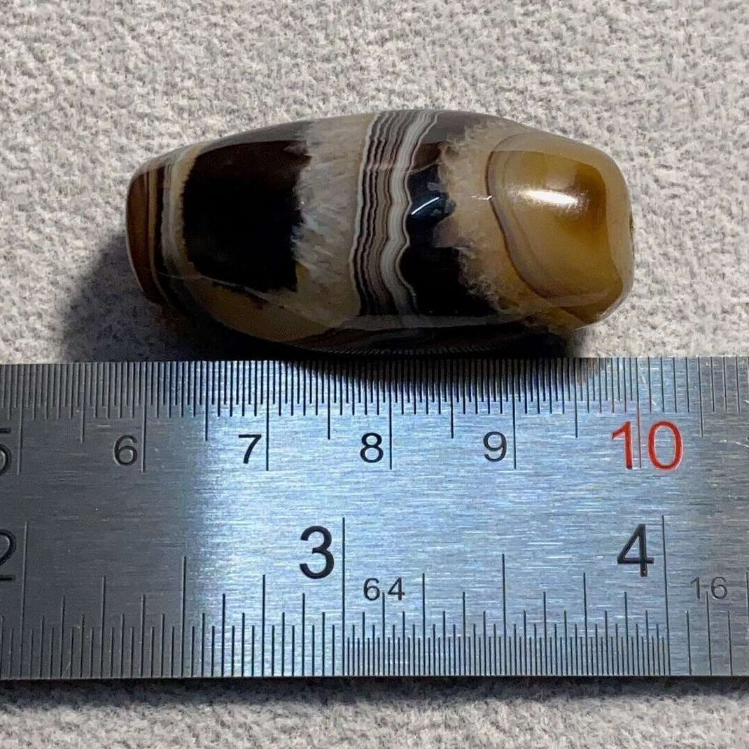 "Vintage African or Himalayan Tibetan Sulaimani agate bead featuring beautiful and vibrant stripes, showcasing a unique and natural pattern, with a rich history and cultural significance in African and Tibetan beadwork traditions."