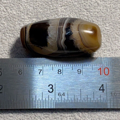 "Vintage African or Himalayan Tibetan Sulaimani agate bead featuring beautiful and vibrant stripes, showcasing a unique and natural pattern, with a rich history and cultural significance in African and Tibetan beadwork traditions."