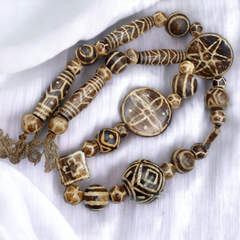 Vintage Pumtek beads necklace with unique and intricate patterns, featuring a rare and eclectic mix of colors and textures. The necklace showcases a variety of shapes and sizes, creating a truly one-of-a-kind piece of jewelry.