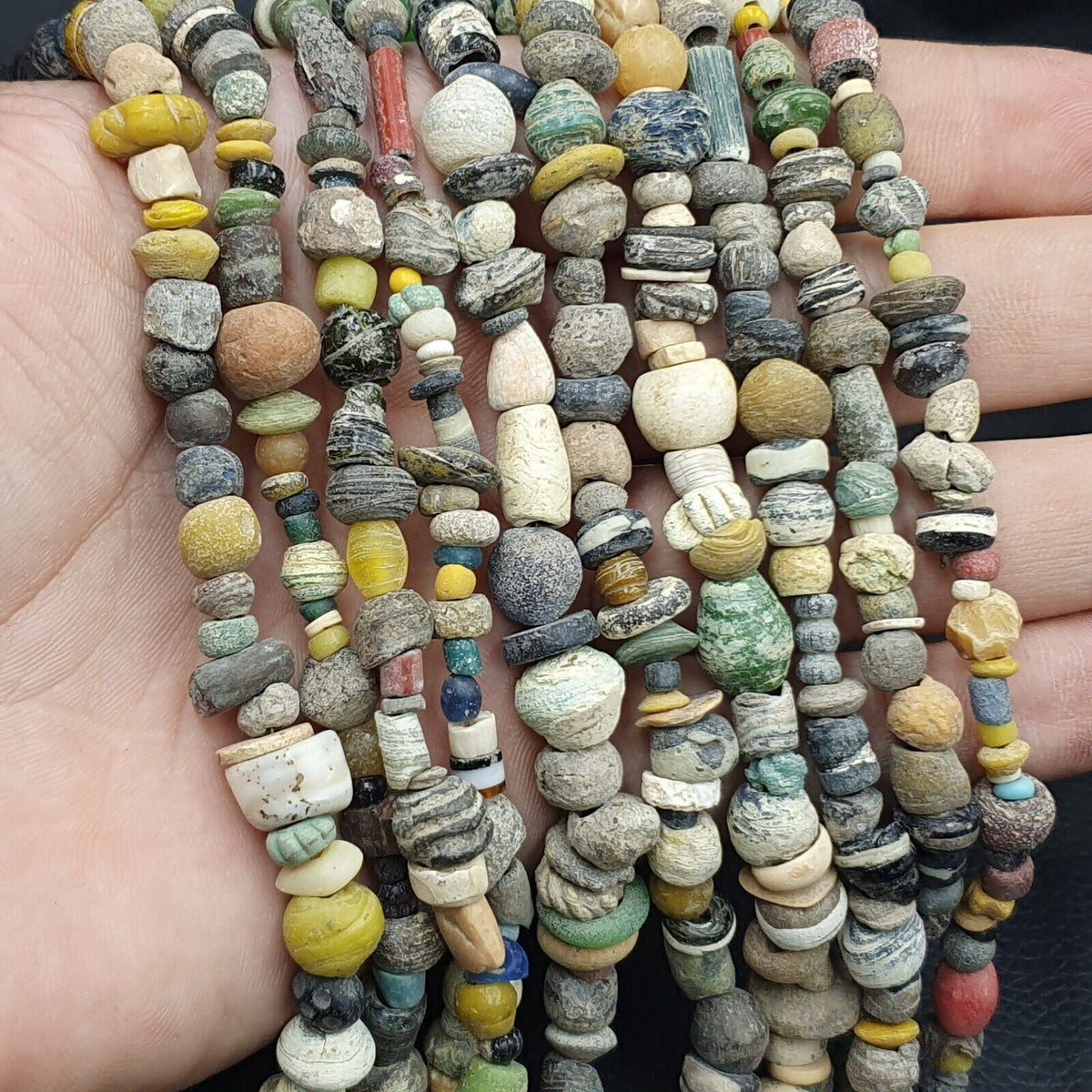 "RM-2: A stunning authentic ancient strand necklace from the Islamic Roman Era, featuring six strands of expertly crafted beads. Each bead tells a story of a bygone era, showcasing intricate designs and patterns that have stood the test of time. A true treasure for collectors and history enthusiasts, this necklace is a rare and precious find."