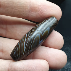 "Antique Yemeni collectible agate bead featuring natural banded agate patterns, showcasing the unique signature of nature's craftsmanship."