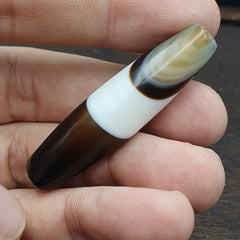Close-up of a collectible Yemeni agate bead showcasing its authentic banded beauty