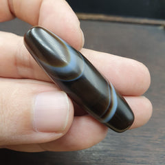 Antique Yemeni collectible agate bead showcasing natural banded pattern. Unique vintage jewelry piece with historical significance.