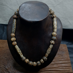  Pumtek beads, revered for their historic significance and intricate patterns. Each bead, hewn from authentic Palm Wood Stone, exudes a unique charm and character, adding to the necklace's allure. With its fusion of traditional artistry and contemporary style, this necklace is a testament to the art of adornment and a celebration of Asian aesthetics. Elevate your look with this one-of-a-kind piece that tells a story of heritage, craftsmanship, and natural beauty.