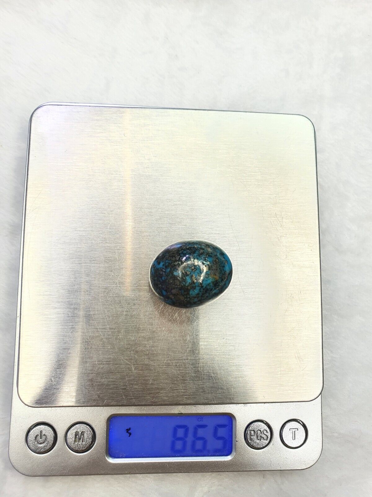 一顆橢圓形正宗天然綠松石，帶黃鐵礦基質凸圓面 86 克拉