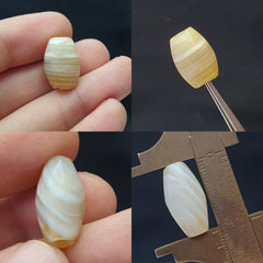 "Image of 2 ancient Sulaimani agate stone beads from Pakistan, used as amulets, showcasing a rare and precious find from a bygone era, with intricate patterns and a rich cultural heritage."
