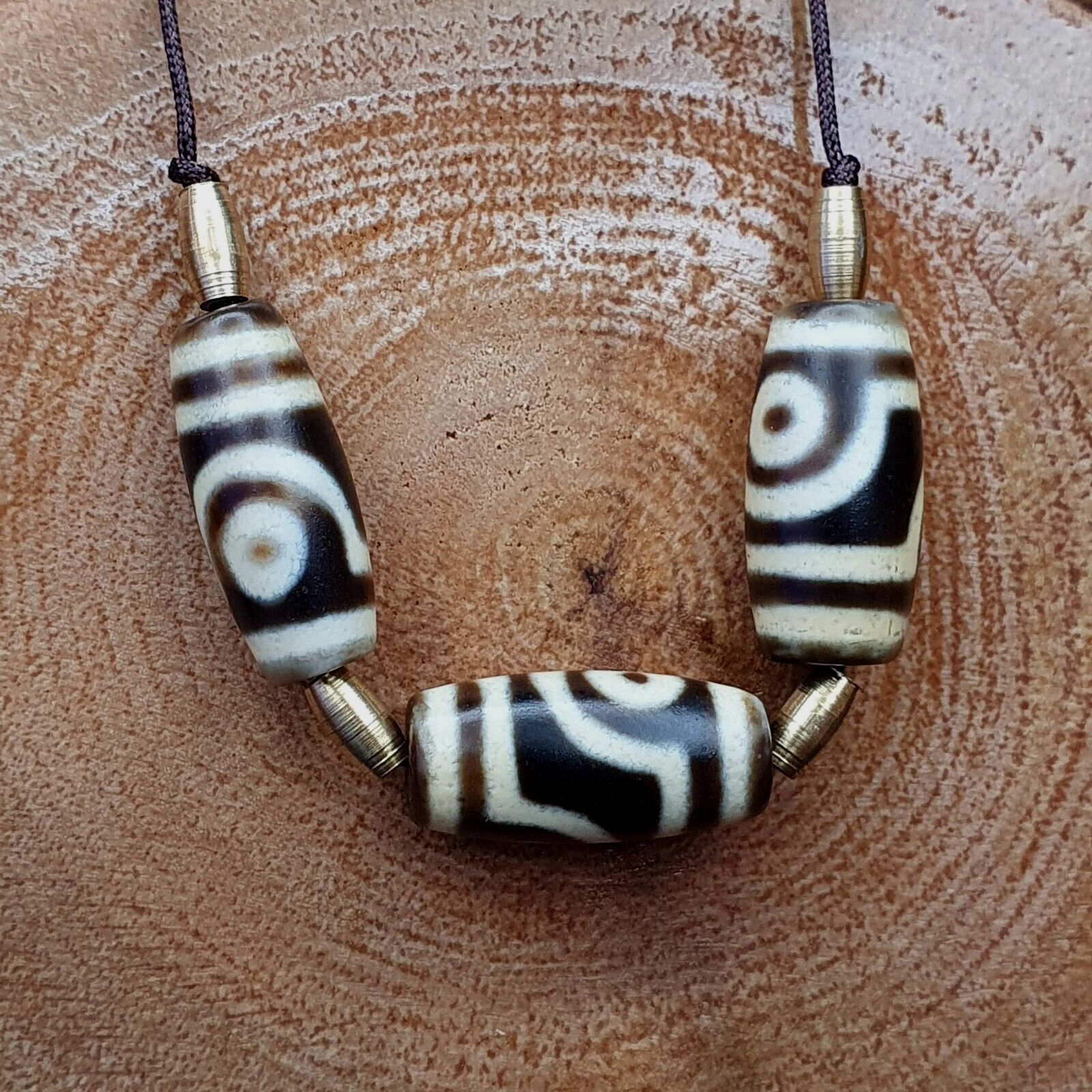 "Image of 3 rare and ancient Himalayan Indo-Tibetan 2 eyes Dzi amulet beads, showcasing unique and intricate patterns, believed to possess spiritual powers and bring protection and good fortune in Tibetan Buddhism."