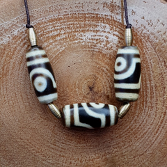 "Image of 3 rare and ancient Himalayan Indo-Tibetan 2 eyes Dzi amulet beads, showcasing unique and intricate patterns, believed to possess spiritual powers and bring protection and good fortune in Tibetan Buddhism."