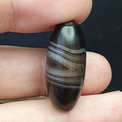 "Image of an extremely rare and antique Himalayan Indo-Tibetan agate bead amulet, showcasing a unique and intricate pattern, believed to possess spiritual powers and bring protection and good fortune in Tibetan Buddhism, a true collector's item and a piece of cultural history."