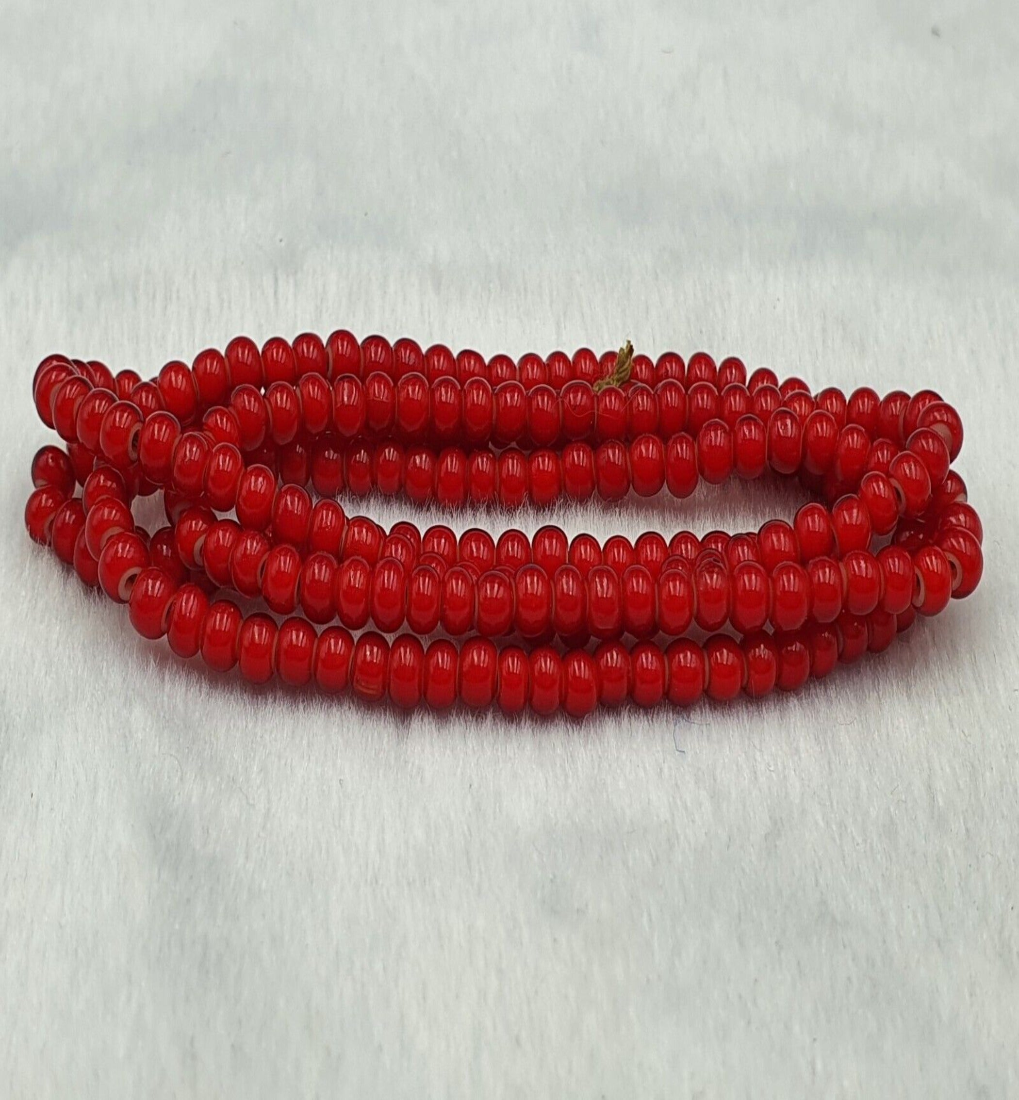 "Antique Venetian RED White Heart Trade Beads long strand necklace. A vibrant red and white heart-shaped bead necklace with intricate designs, strung on a long strand. The beads have a vintage, distressed appearance, adding to their antique charm."