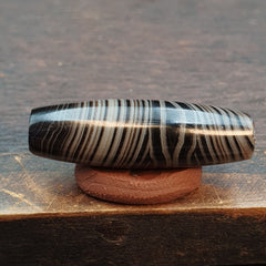 "Himalayan Indo-Tibetan agate bead featuring the revered Suleimany Lines pattern, showcasing a intricate and sacred design, said to bring spiritual protection and blessings, with a rich history and cultural significance in Tibetan Buddhism."