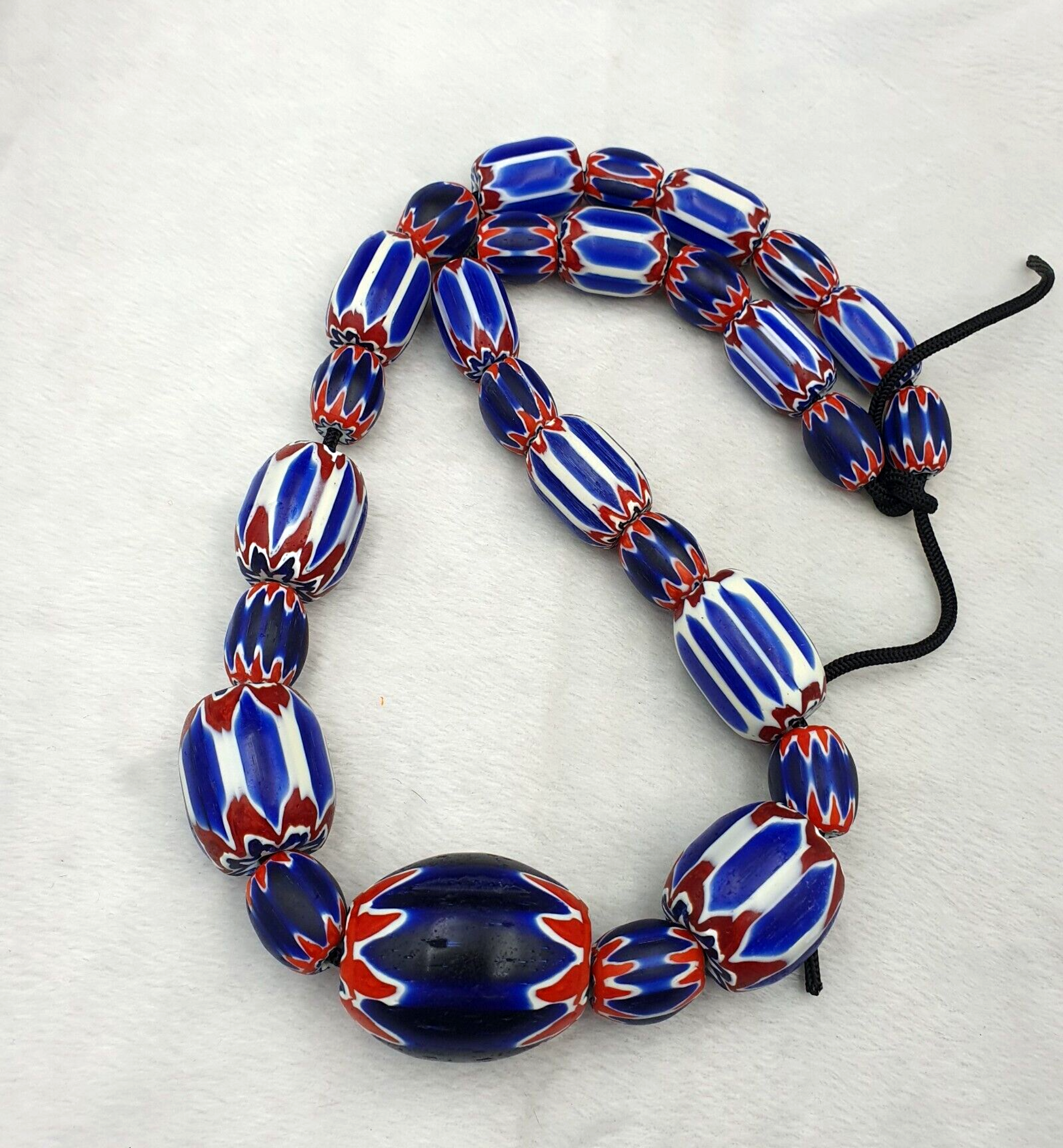 "Venetian Style Trade Beads: A stunning long necklace featuring blue chevron glass beads in a intricate, layered design, evoking the classic Venetian style of trade beads. The beads shimmer in shades of blue, from light sky blue to deep navy, creating a beautiful, eye-catching effect."