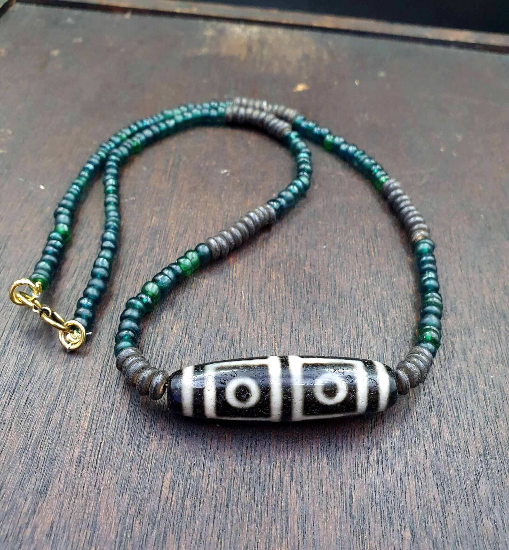 "Four Eyes Pattern Antique Black Tibetan Agate Dzi Bead Amulet Necklace: A rare and sacred vintage necklace featuring a handcrafted black Tibetan agate Dzi bead with a four eyes pattern, believed to bring spiritual protection and good fortune. The bead has a smooth,
