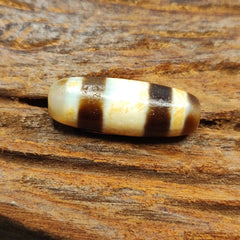"Two antique Tibetan Agate Dzi beads, featuring a unique 'stripes' pattern, highly valued as an amulet (124). These high-quality beads are believed to bring good fortune, protection, and spiritual growth to the wearer. Originating from Tibet, they showcase exceptional craftsmanship and cultural heritage, with the distinctive stripes pattern adding to their rarity and significance."